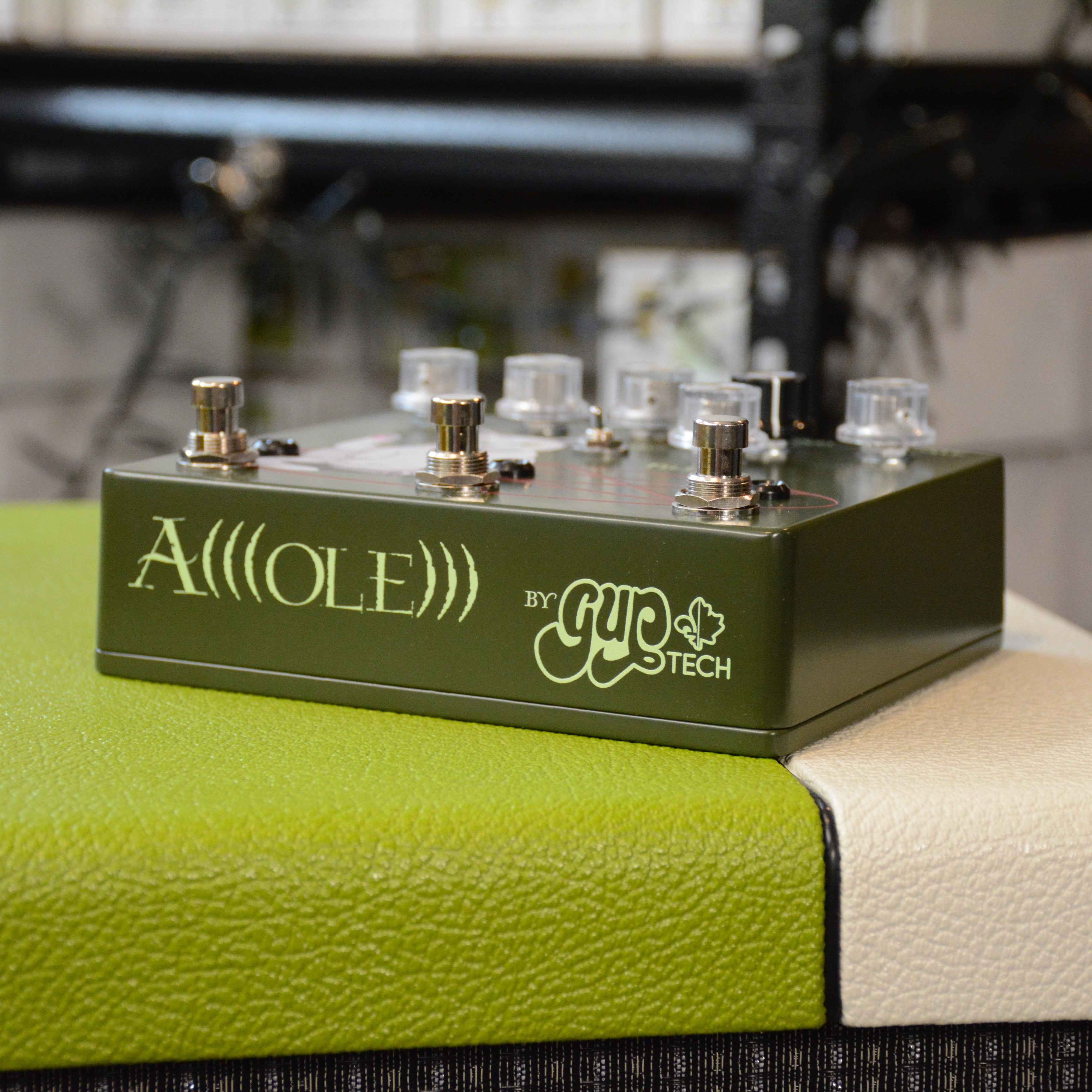 A(((ole))) fuzz-octa-boost cute cat on an army green double enclosure, side with name and logo.
